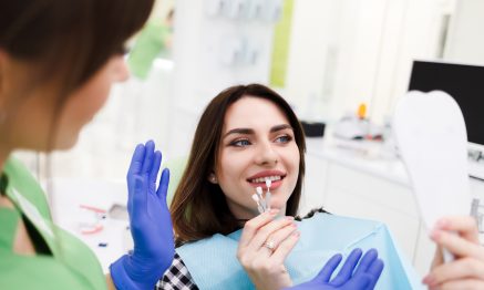 Patient checking teeth shade in mirror after doing Veneer treatment